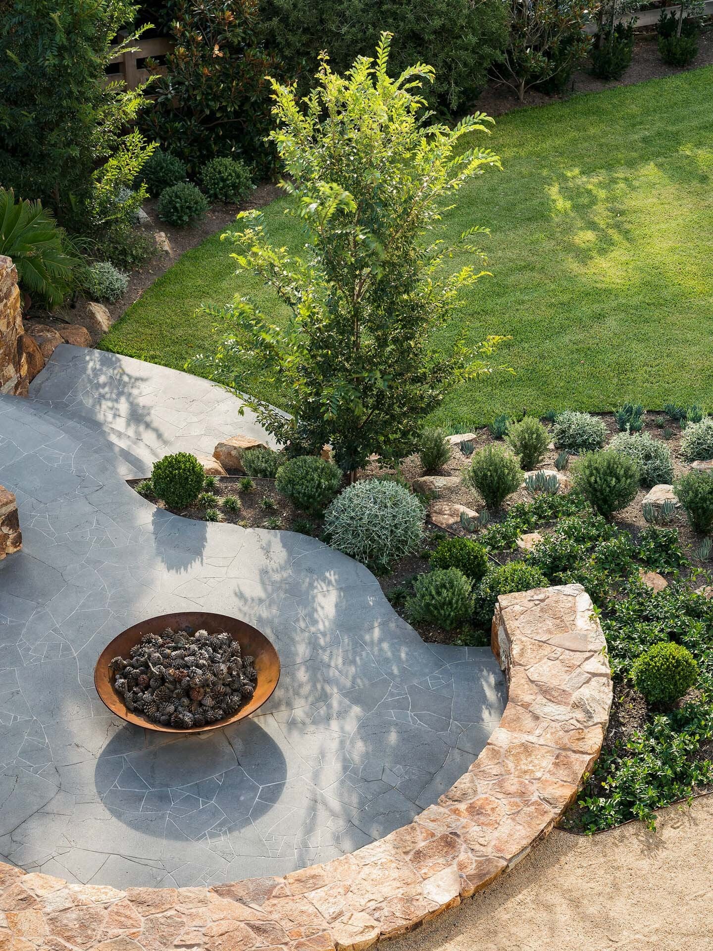 A backyard with a fire pit and landscaping.