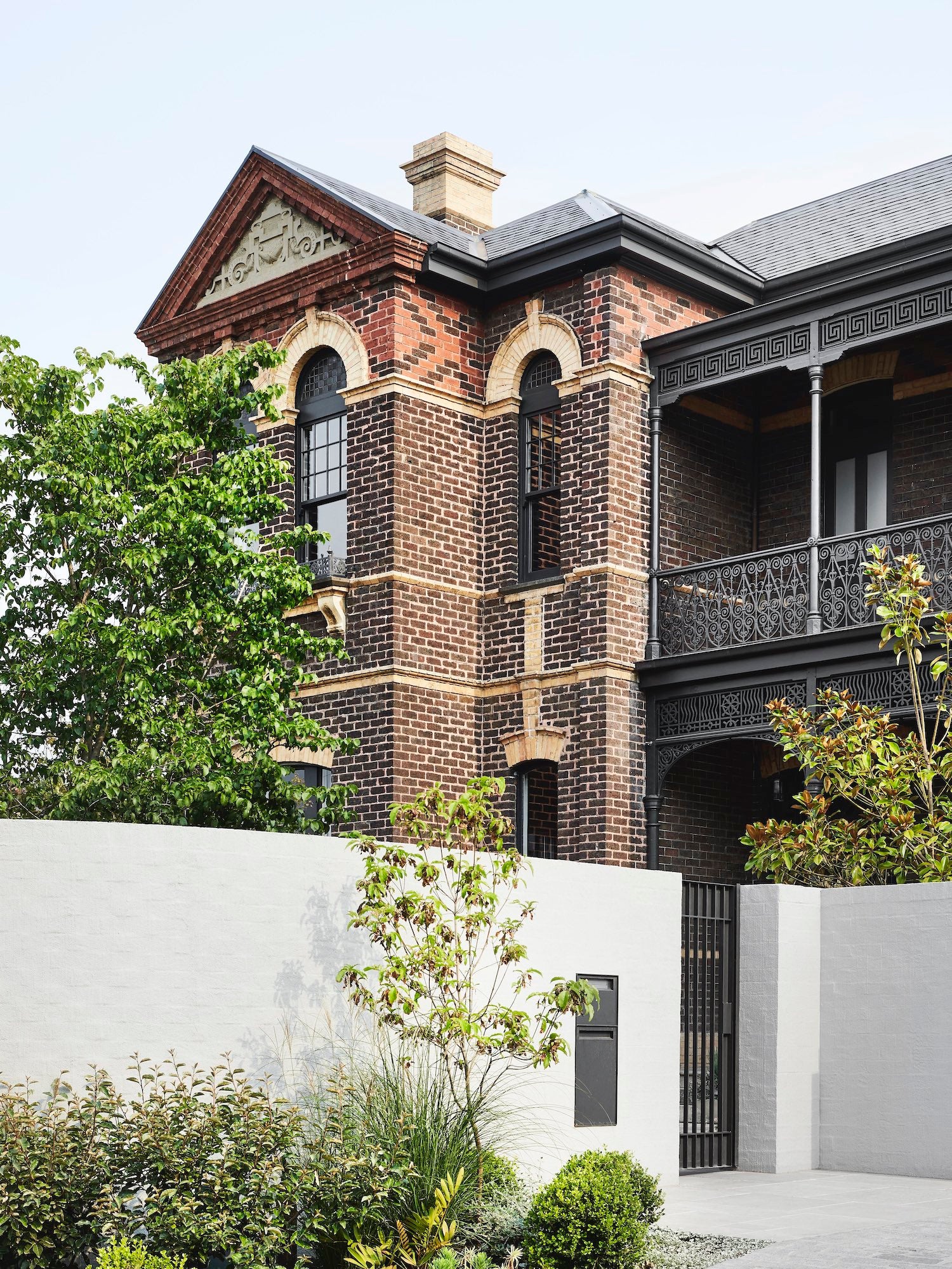 A brick armadale house with a fence and a gate.